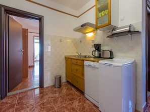 A compact kitchen with a dishwasher, a coffee maker, and a toaster. - Apartments Beba (Novi Vinodolski)
