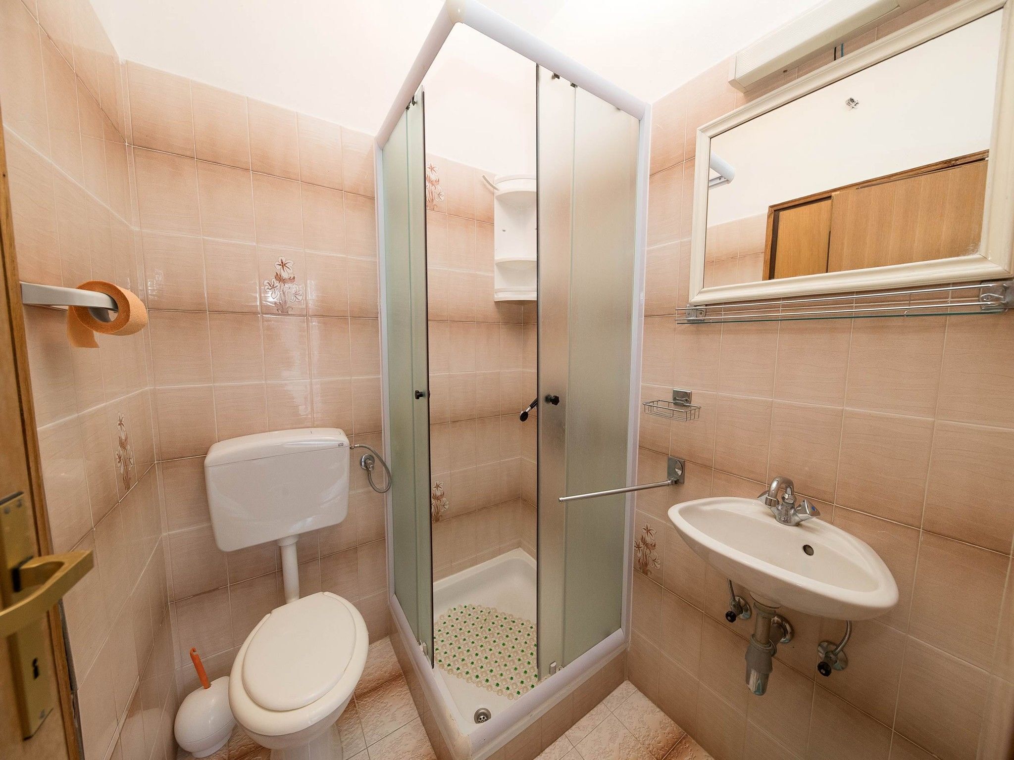 Une salle de bain avec des toilettes, une douche et un lavabo.