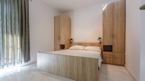Un dormitorio con una cama grande, un armario de madera y una mesita de noche.