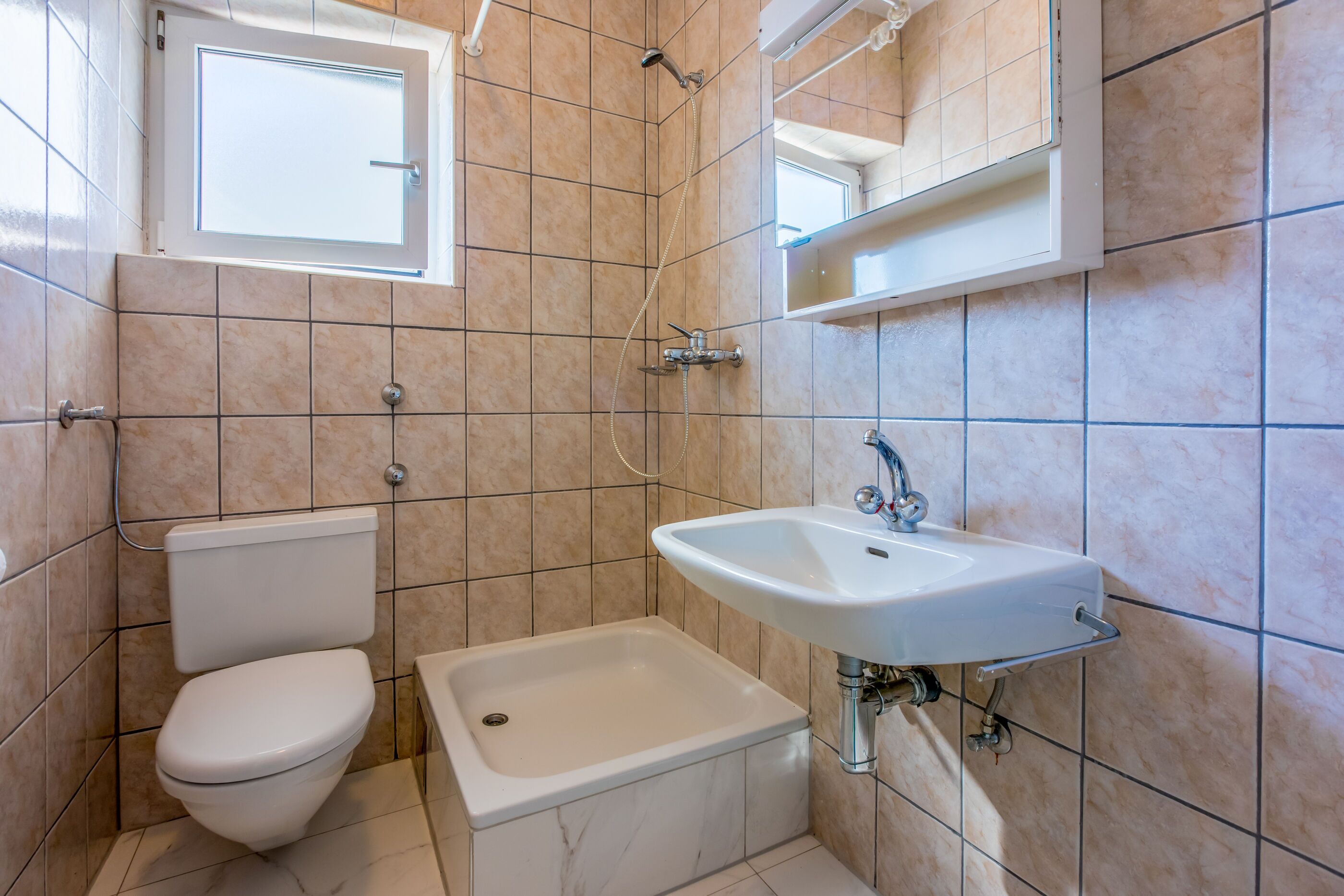 Een badkamer met een toilet, een bad en een wastafel.