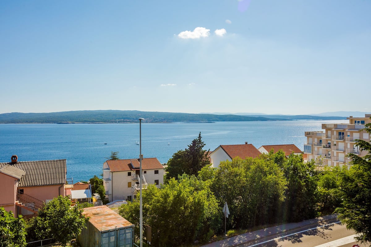 A coastal town with buildings overlooking a large body of water.