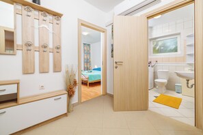 A modern bathroom with a sink, toilet, and mirror. - Apartments Pinty (Jadranovo)