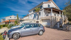 A two-story house with a stone staircase and a car parked in front. - Apartments Adriatic (Crikvenica)