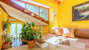 A bright yellow room with a staircase, a sofa, and a coffee table. - Apartments Senka (Dramalj)