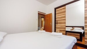 Une chambre d’hôtel avec un grand lit, une armoire en bois et un miroir.