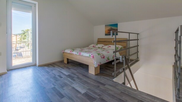 Ein Schlafzimmer mit Bett, Fenster und einem Bild an der Wand.