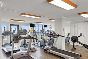 A gym with treadmills, elliptical machines, and stationary bikes. - 11th floor paradise! (Panama City Beach)