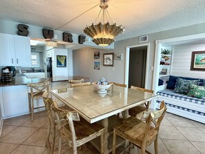 A dining area with a glass-top table, wooden chairs, and a decorative bowl centerpiece.