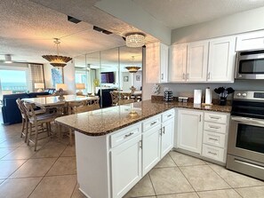 A modern kitchen with white cabinetry, granite countertops, and stainless steel appliances. - 11th floor paradise! (Panama City Beach)