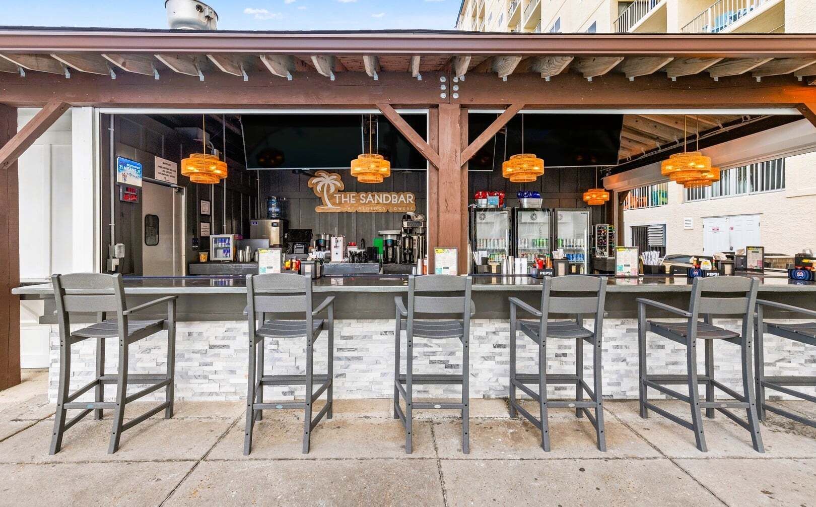 An outdoor bar area with a counter and multiple bar stools.