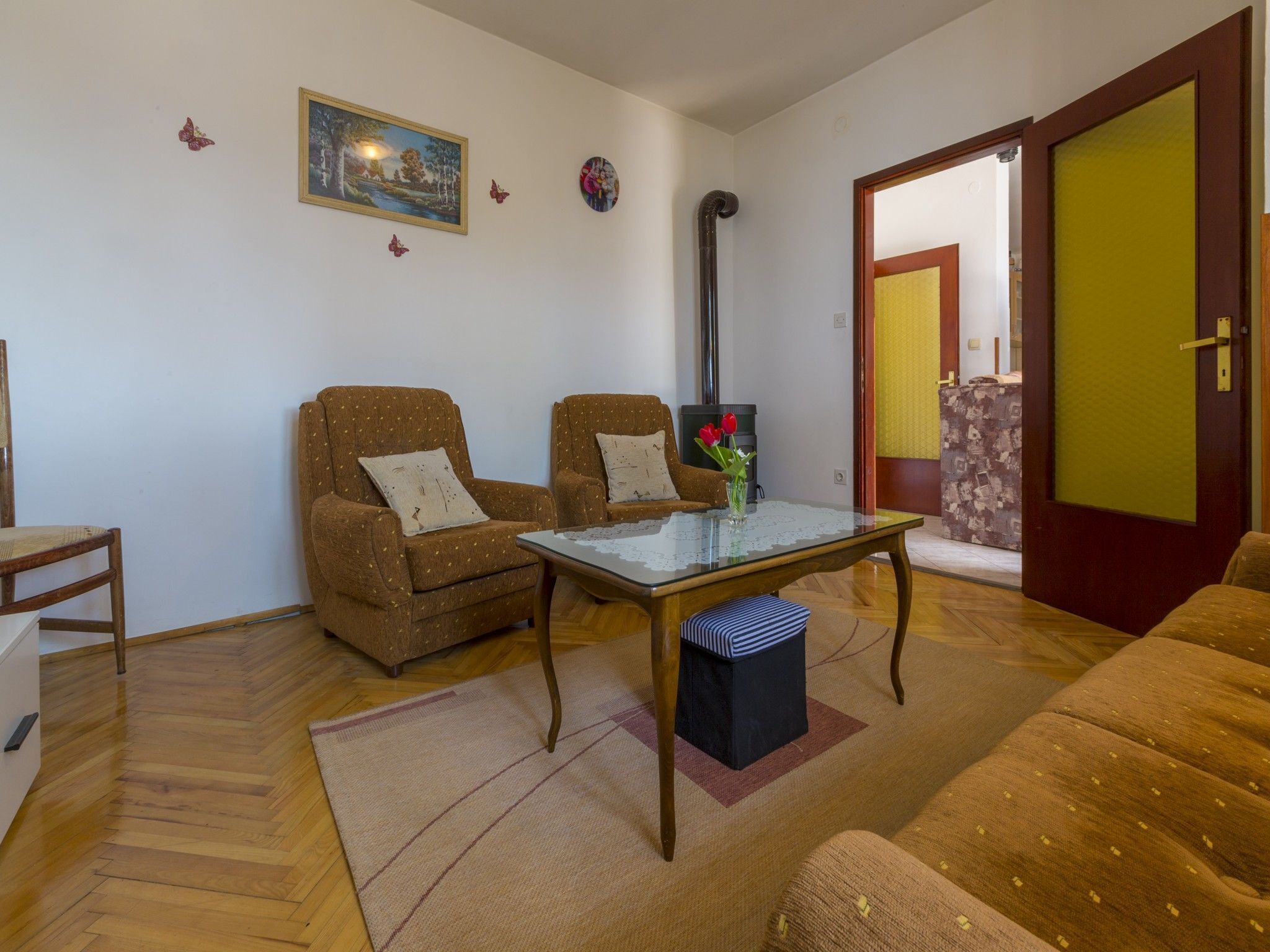 Ein gemütliches Wohnzimmer mit zwei braunen Sofas, einem Glastisch und Holzboden.