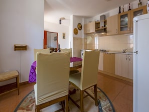 A compact kitchen with wooden cabinets, a built-in oven, and a refrigerator. - Apartments Lilin (Crikvenica)