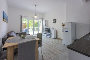 Eine moderne Küche mit Essbereich, einem Kühlschrank und einem Fernseher.
