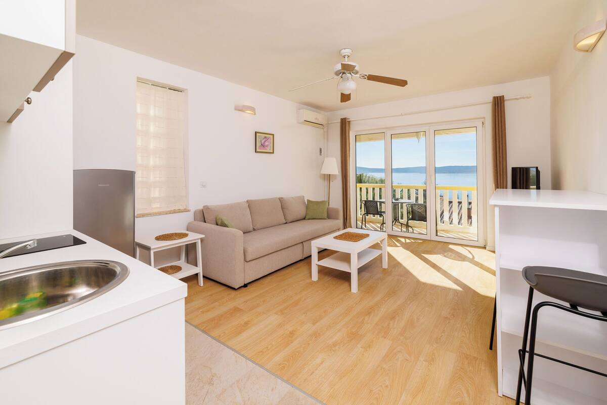 A modern living room with a sofa, coffee table, and a balcony with a view.