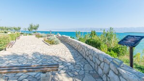 A stone pathway leading to a scenic overlook with a view of the sea and mountains. - Apartment Seka (Sabunike)