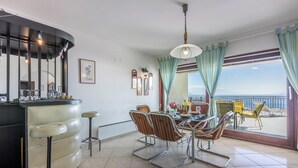 A dining area with a bar, chairs, and a view of the outdoors.