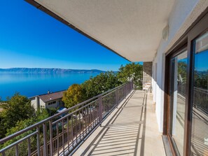 Een balkon met uitzicht op een meer en verre bergen.