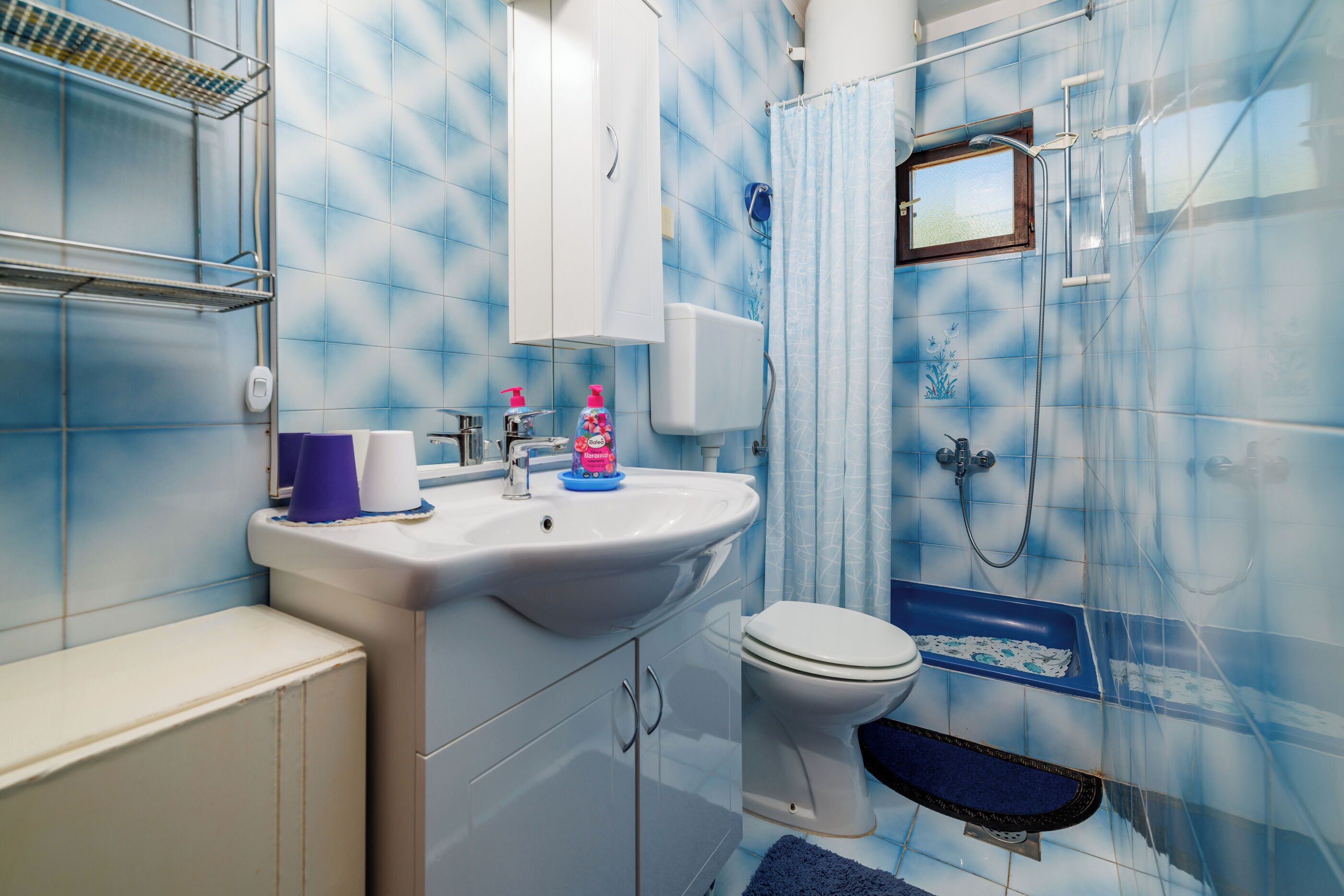 A bathroom with a sink, toilet, and shower.