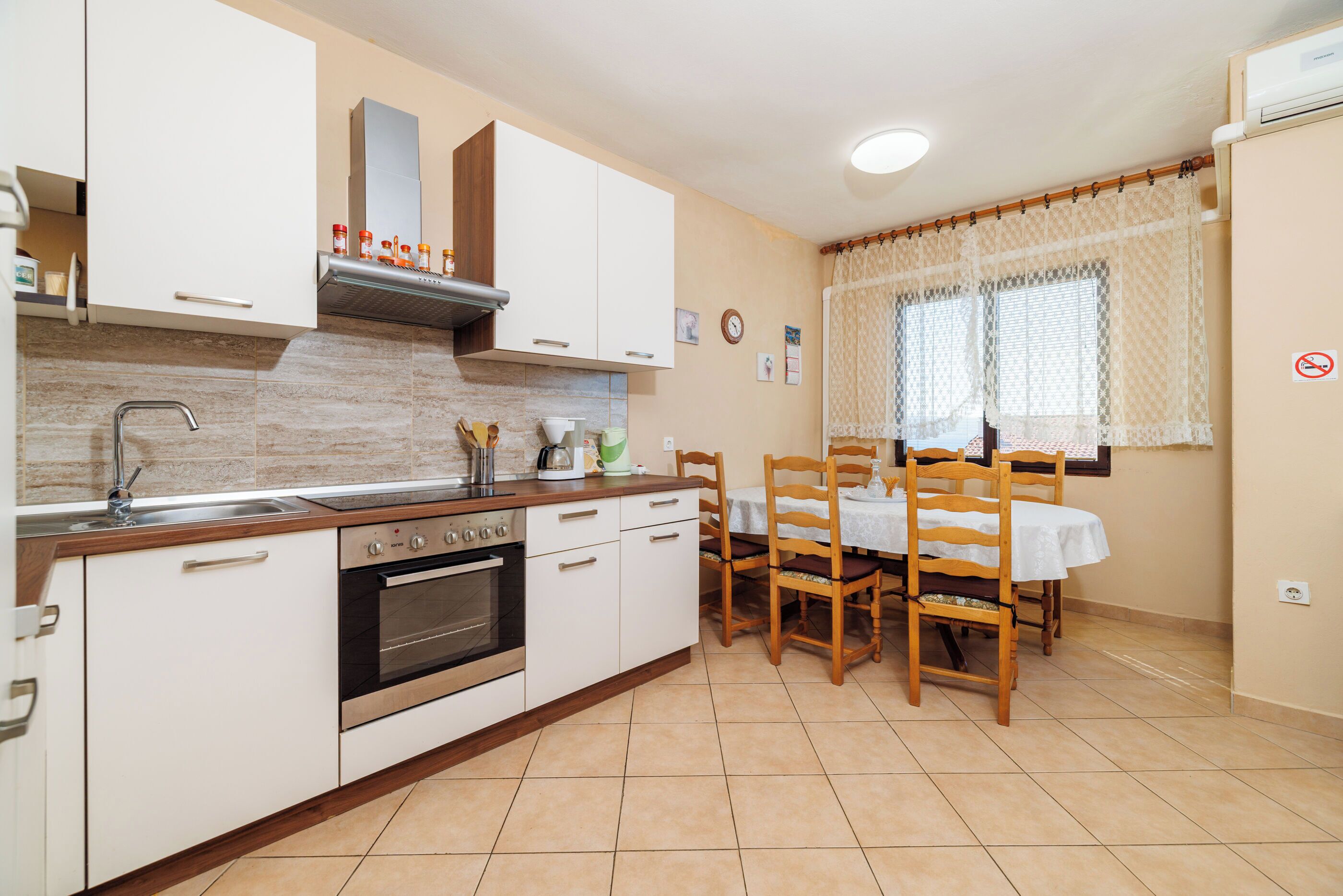 A kitchen with white cabinets, a stove, and a dining table with chairs.