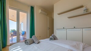 Et hotelværelse med seng, balkon med stole og et lille bord.