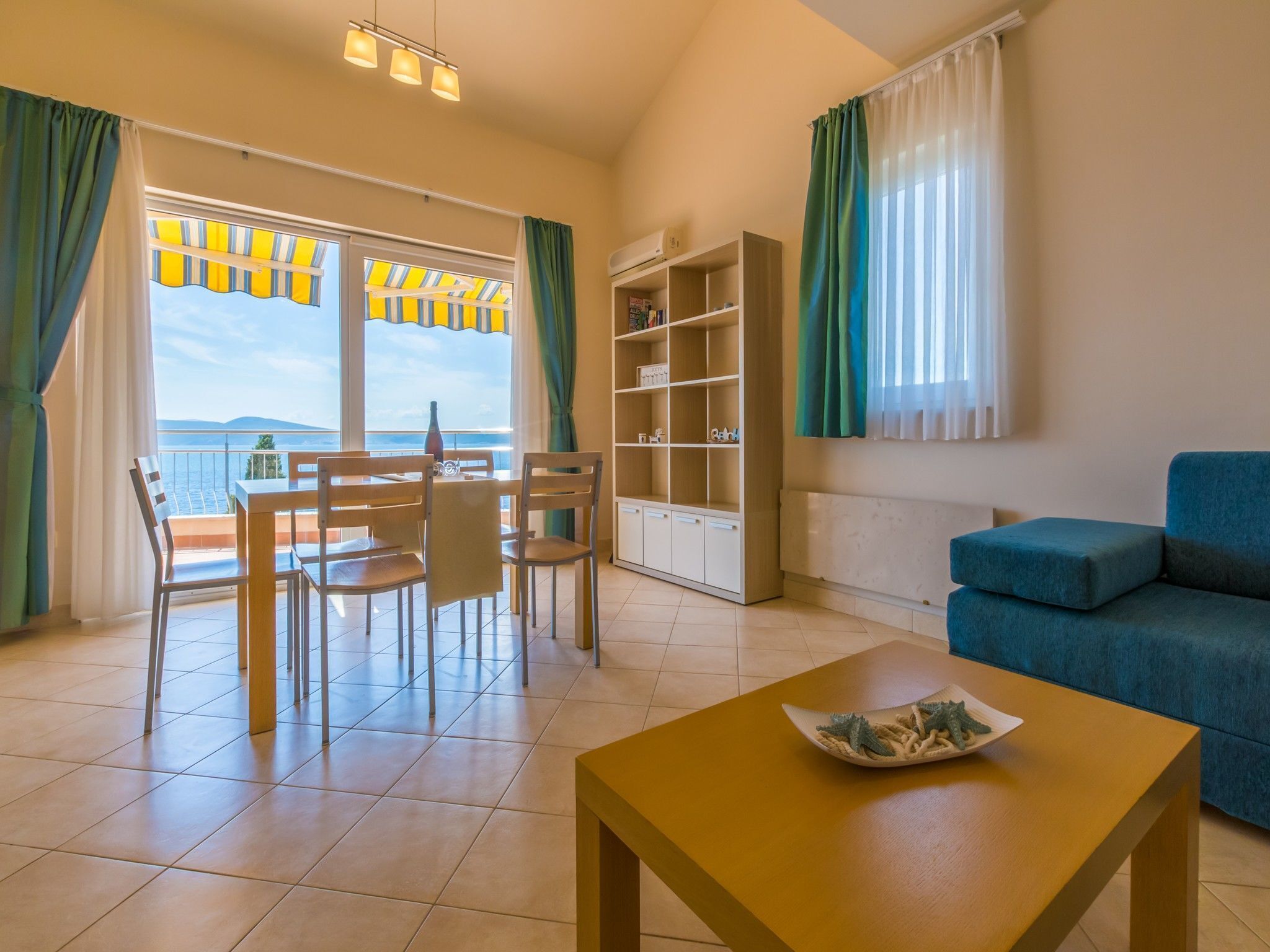 Ein Wohnzimmer mit Essbereich, einer Couch und Meerblick.