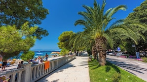 A seaside promenade with palm trees, a beach, and a clear blue sky. - Apartment Jana (Crikvenica)