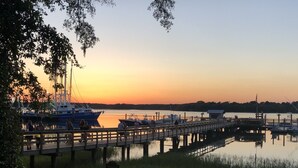 A pier with boats docked, a calm water body, and a sunset in the background. - 8/27- 9/4  open  5 STARS  Great ratings- Hidden Gem Great Lagoon/Golf/pool view (Hilton Head Island)