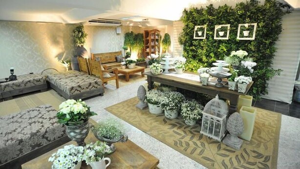 Una sala de estar con sofá, mesa de centro y plantas decorativas.