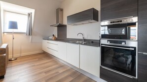 A modern kitchen with a built-in oven, microwave, and stainless steel appliances.