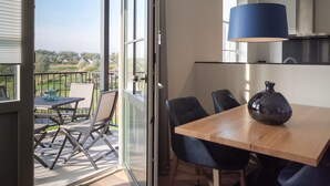A modern dining area with a wooden table, black chairs, and a blue lamp.