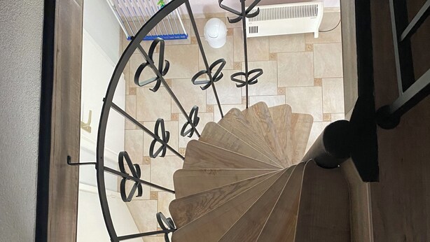 Eine Wendeltreppe mit Holzvertäfelung und Metallgeländern.