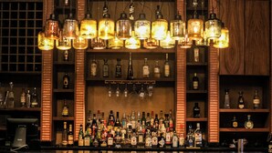 Un bar bien fourni, avec de nombreuses bouteilles de spiritueux et une grande variété de verres.