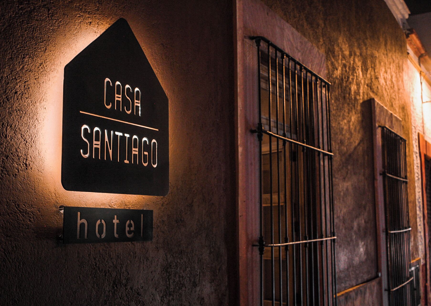 A sign for 'Casa Santiago Hotel' with a simple, dark background and white lettering.