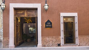 Une entrée d’immeuble avec une enseigne indiquant « CASA SANTIAGO » et une porte dotée d’un portail en métal.