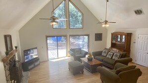 A spacious living room with a high ceiling, large windows, and a fireplace. - Quail Run 4,000 Sq.Ft Largest and Most Beautiful Cabin On The Mountain (Pine Mountain Club)