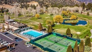 An aerial view of a facility with a swimming pool, tennis courts, and a parking lot. - Quail Run 4,000 Sq.Ft Largest and Most Beautiful Cabin On The Mountain (Pine Mountain Club)