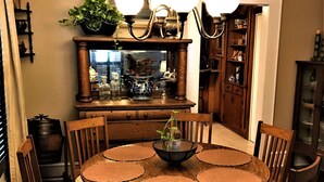 A dining room with a round table, six chairs, a chandelier, and a mirror above the table. - Hughes Street House! (Nacogdoches)
