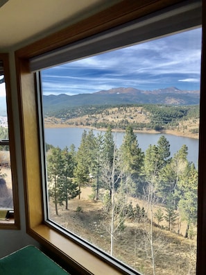 Enjoy a serene lake view from the comfort of this inviting room, featuring a scenic window and a cozy bench.