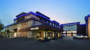 Hotel com placa 'Main Lobby', fachada de pedra e iluminação em neon azul.