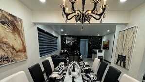 A dining room with a long table set for a meal, surrounded by chairs. - MASSIVE HOME WITH HEATED POOL, NEAR BEACH IN SUNNY SOUTH FLORIDA  (Dania Beach)