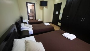 A hotel room with two beds, a TV mounted on the wall, and a wardrobe. - Reina Bilquis (Quito)