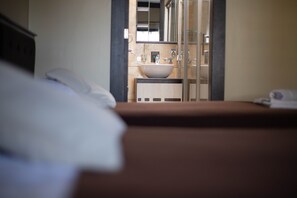 A hotel room with a bed, a bathroom with a sink, and a mirror.