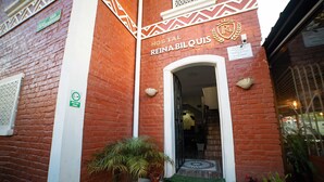 A brick building with a sign reading "Hostal Reina Bilquis." - Reina Bilquis (Quito)