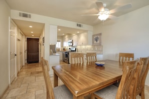 Enjoy meals in this dining area with a large table and six chairs, surrounded by a modern kitchen.