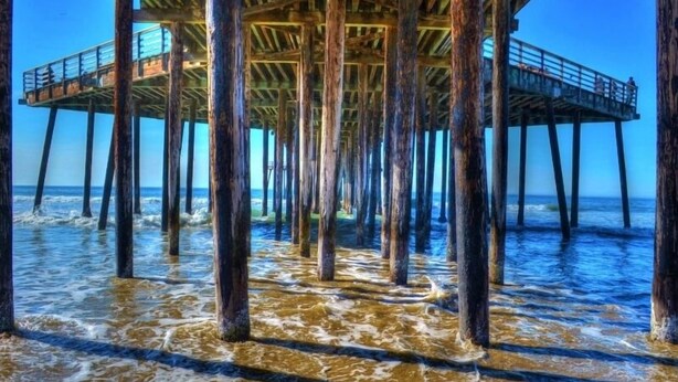 A pier extending into the ocean with wooden supports and a metal railing. - Pismo Shores Paradise #119 - 50yds to beach access (Pismo Beach)
