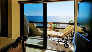 Une pièce dotée d’une porte-fenêtre coulissante donnant sur un balcon avec vue sur l’océan.