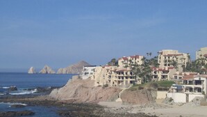 Un hôtel situé sur la côte, composé de plusieurs bâtiments, avec un terrain rocheux et une vue dégagée sur la mer.