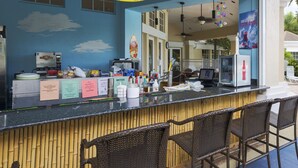A bar area with a counter, chairs, and a sign above the counter.