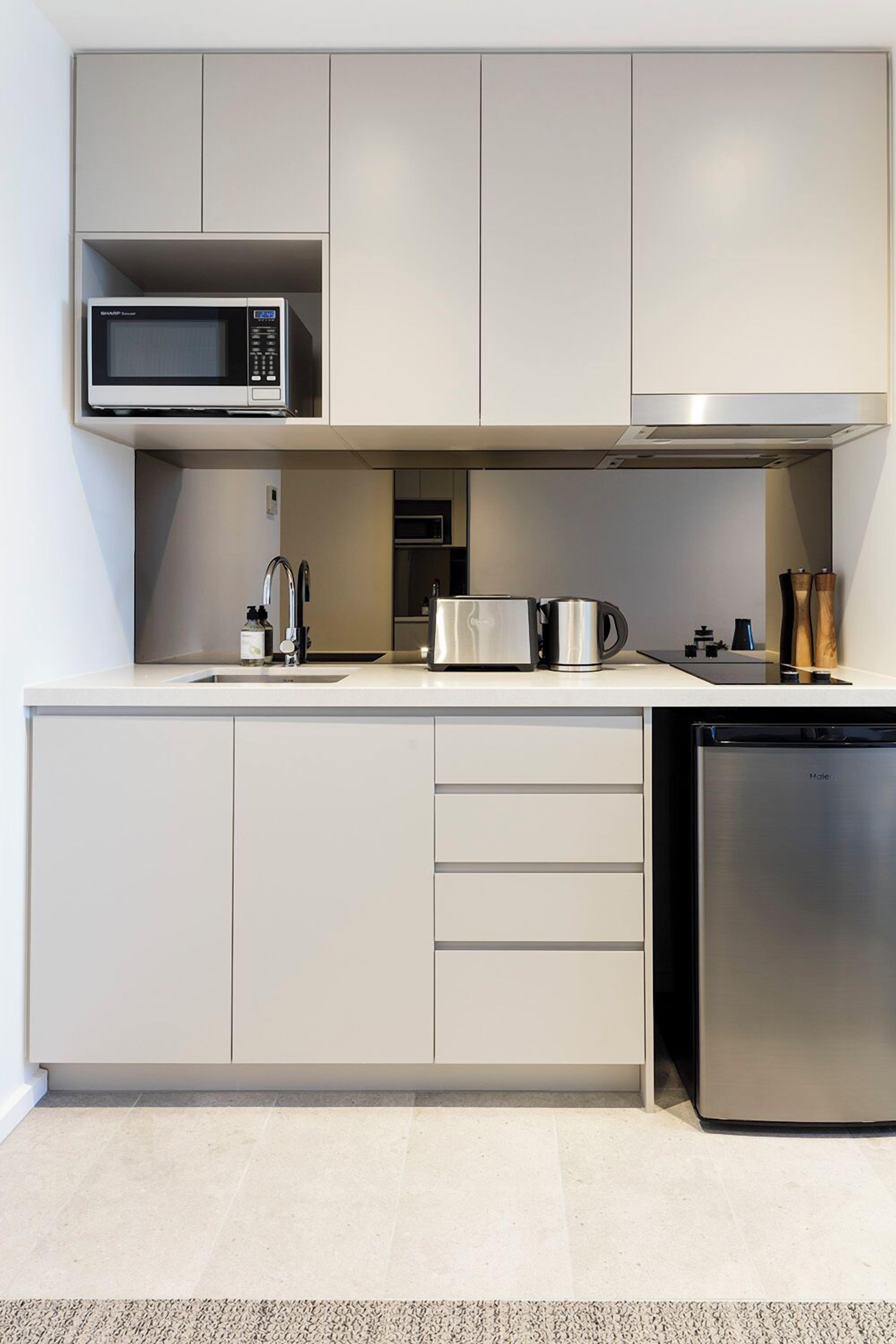 A modern kitchen with a built-in microwave, stainless steel appliances, and a dishwasher.