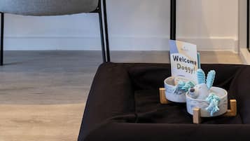 A modern room with a desk, chair, and a welcome sign for guests.